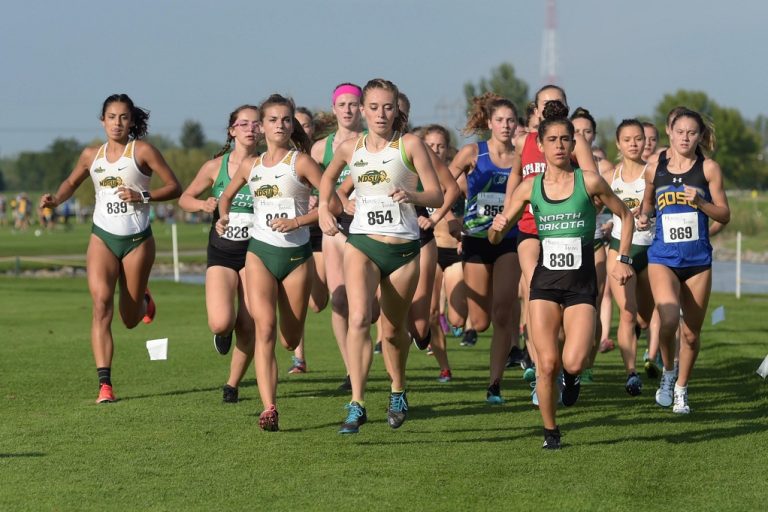 Women running in a collegiate cross-country meet.