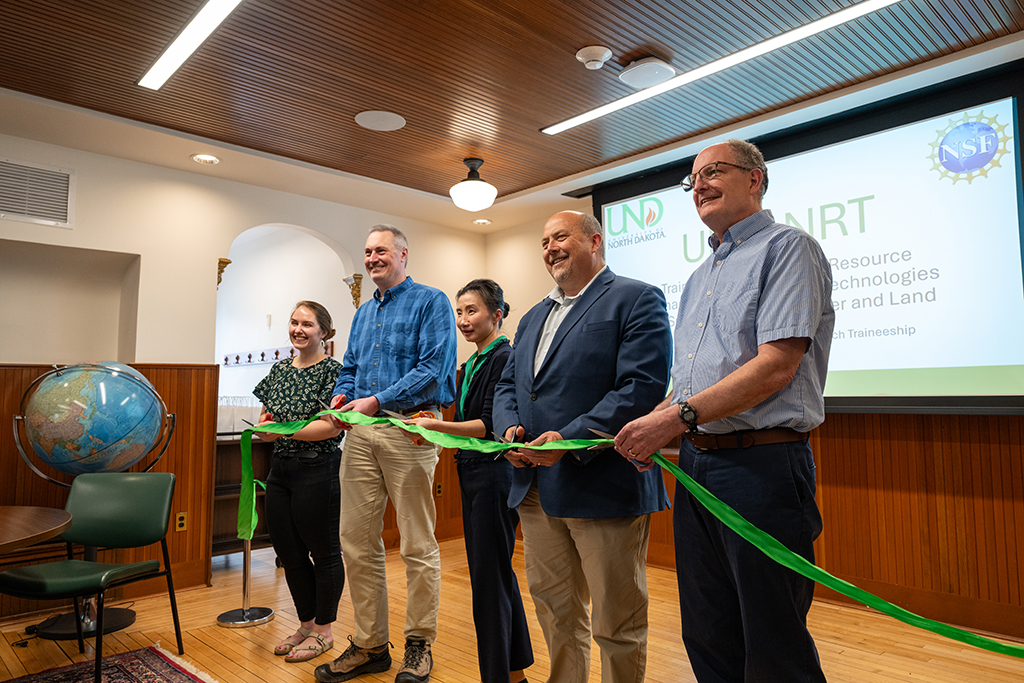 Faculty members celebratee with a ribbon cutting.