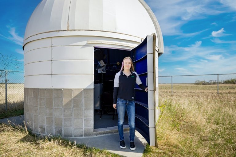 Casia Steinhaus is standing outside UND's observatory.