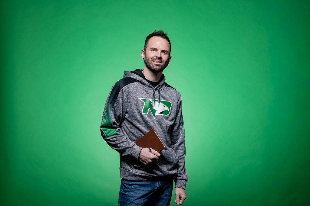 Austin Eskew stands against a UND Green background