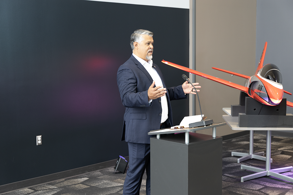 Man at podium with airplane.