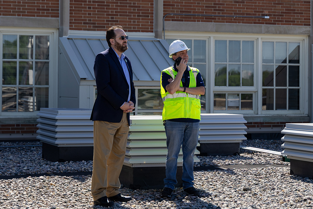 ryan adams and brad knowton watch as antenna is installed