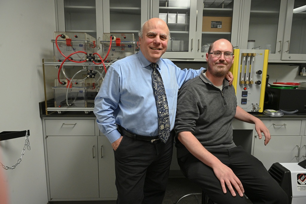 Two man stand next to each other in a lab