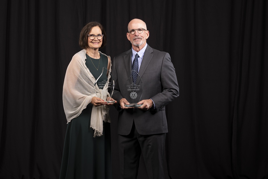 Two people standing in front of a black background