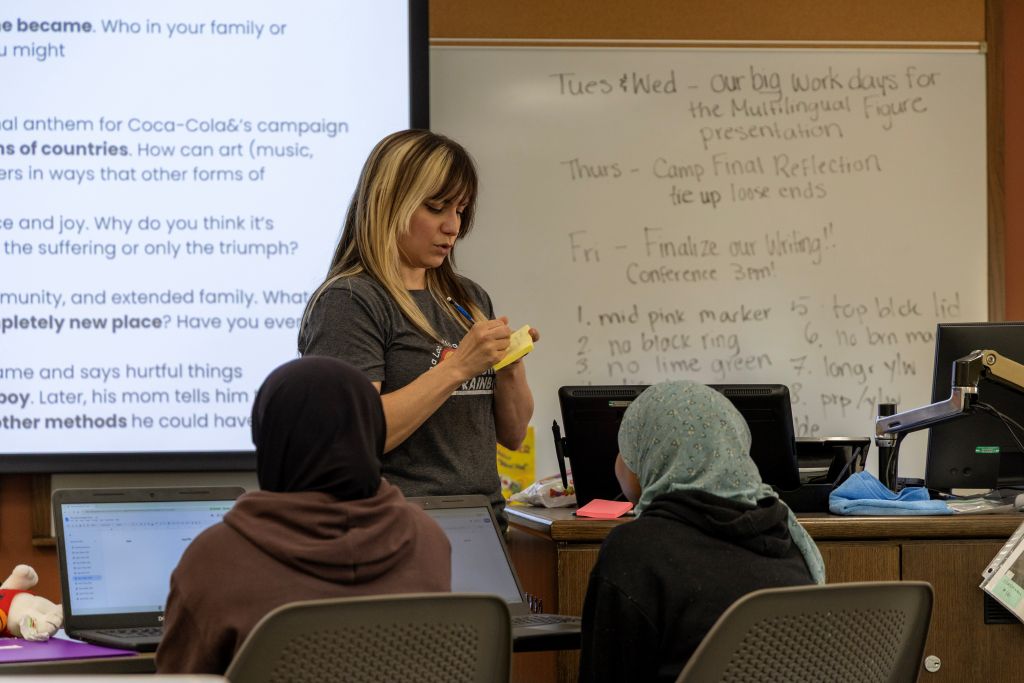 Mrs. Drumm writes on a word on a post it note in class