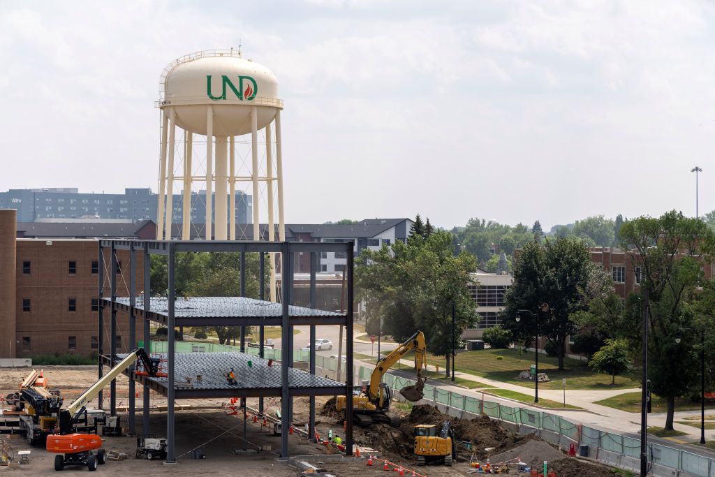 Steel beams and structure erect at construction site of STEM Complex. UND water tower in background.