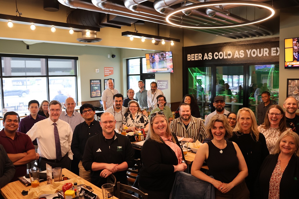 Group of people pose at a social event in a local bar & grill.