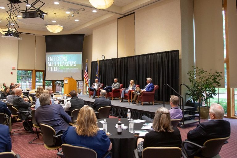 Panel discussoin unfolds on stage at Energize North Dakota summit