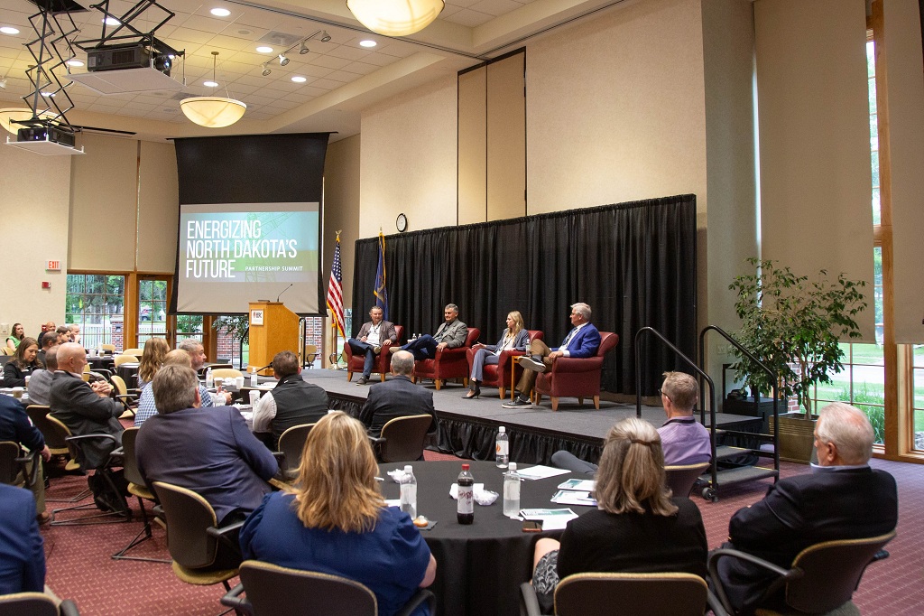 Panel discussoin unfolds on stage at Energize North Dakota summit