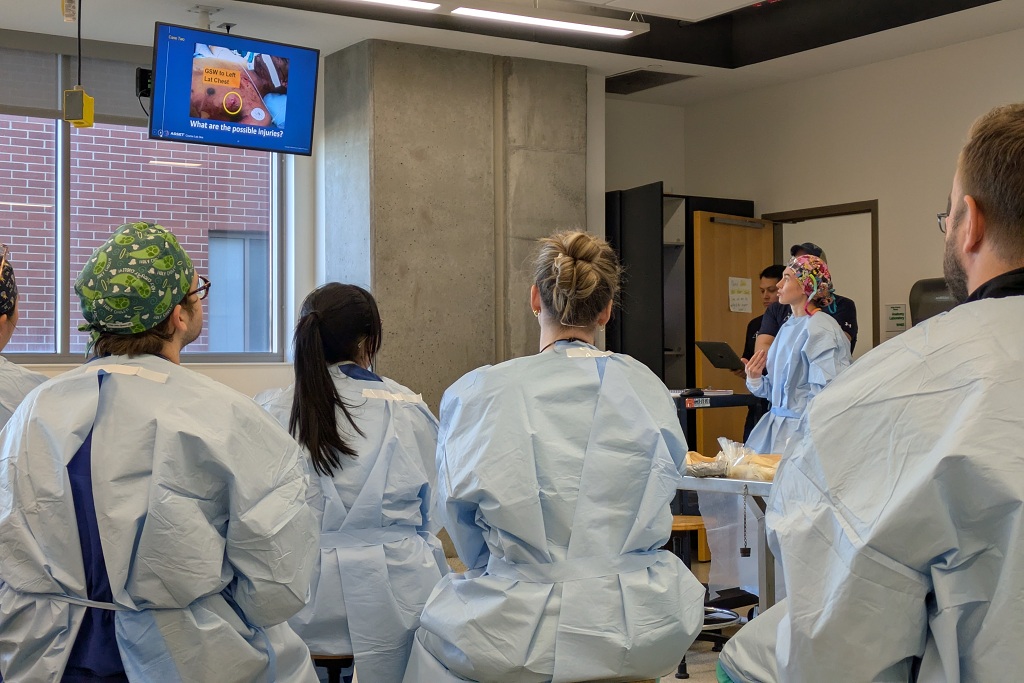 Area surgeons at UND gather around a TV monitor for continuing education training