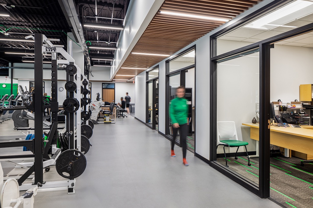 Person walks past offices and athletic equipment in UND's Center for Sports Medicine