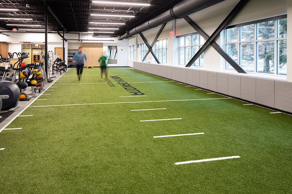 Two people walk on the artificial turf element of the UND Center for Sports Medicine