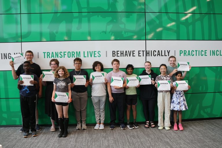 Twlve young people line up to hold certificates for the camera.