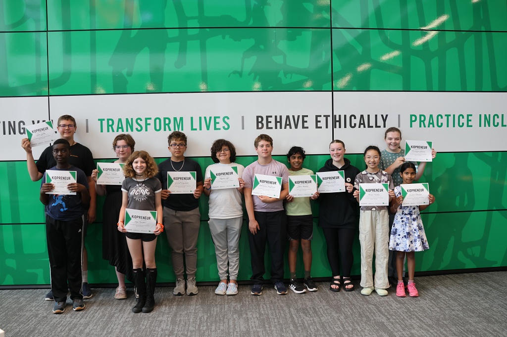 Twlve young people line up to hold certificates for the camera.