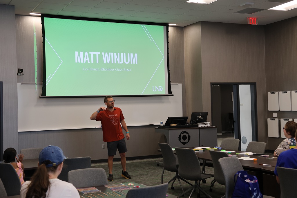 Man at the front of a classroom delivers a presentation