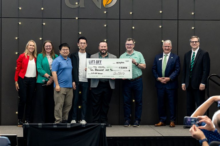 Members of ND Vocal team hold grand prize check with Andy Armacost as Scott Snyder and Eric Link look on