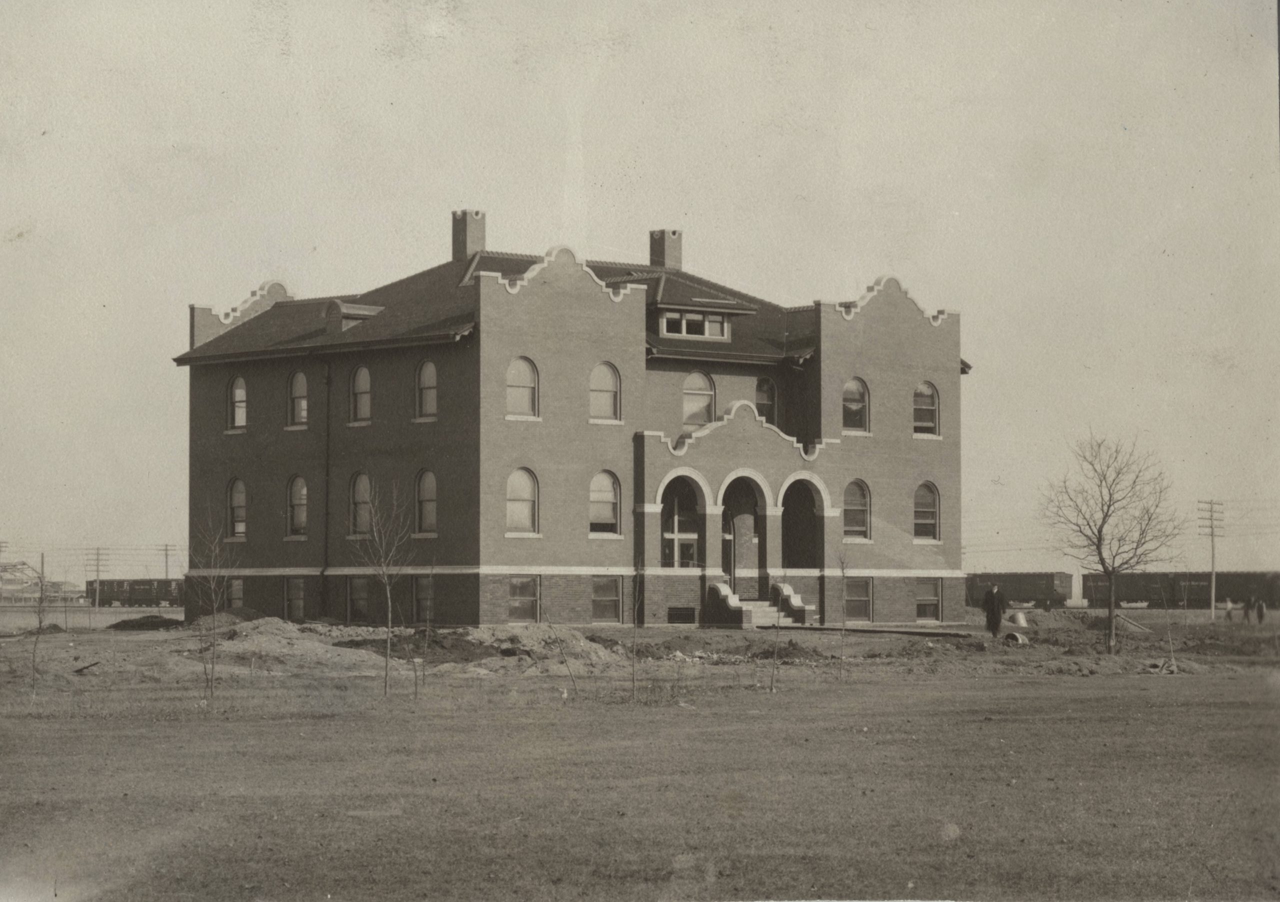 Historic black-and-white photograph of Babcock Hall shortly after its construction in 1907, showing the three-story brick academic building surrounded by undeveloped grounds.