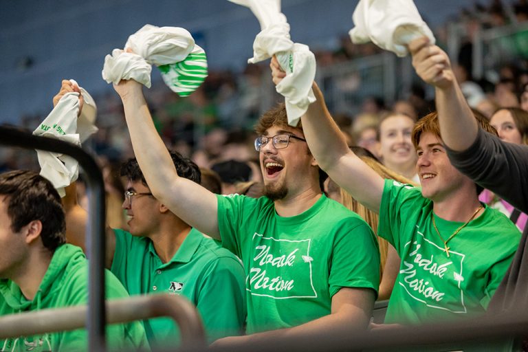 UND fans waving towels while cheering at football game