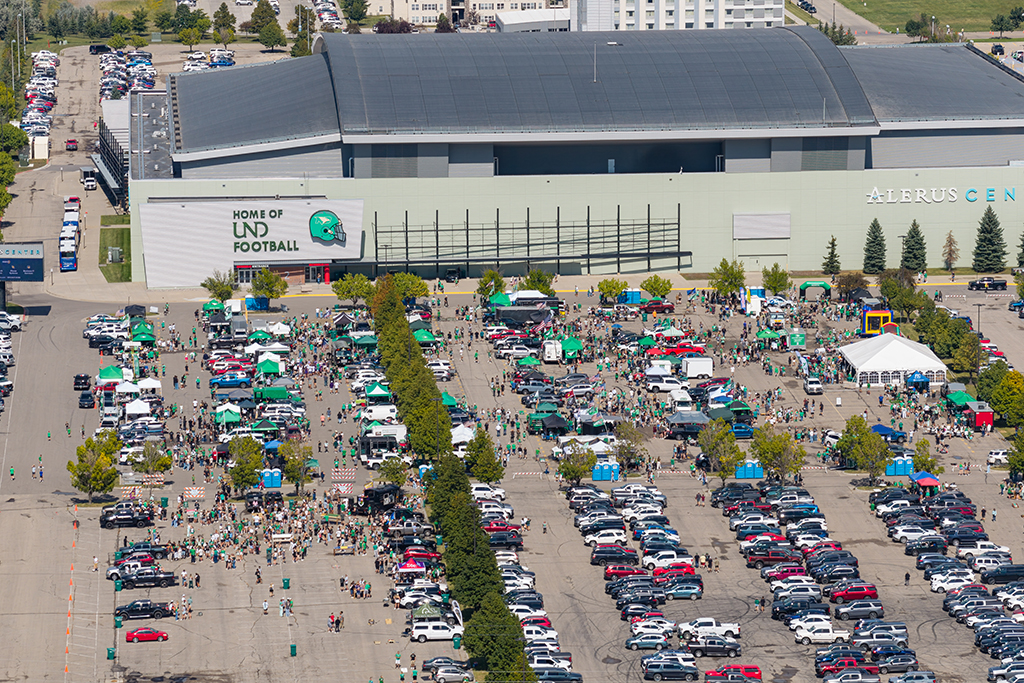 Aerial view of crowds, tents, vehicles and tailgating activities filling the parking lot outside the Alerus Center.