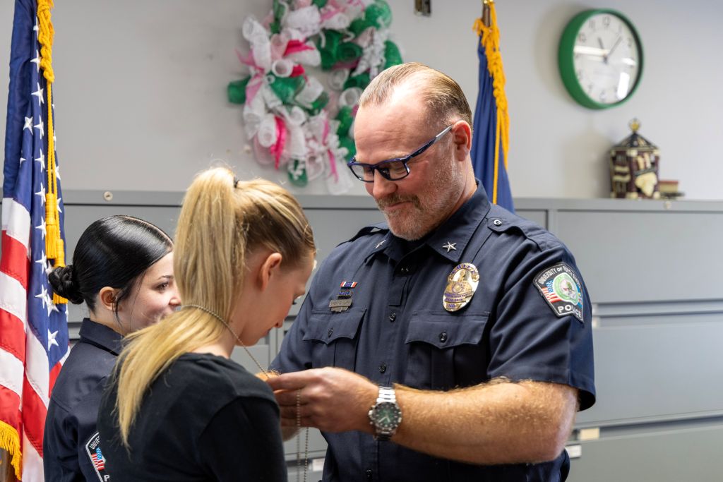 Police Chief Rodney Clark places a police badge around Josie Beltz’s neck.