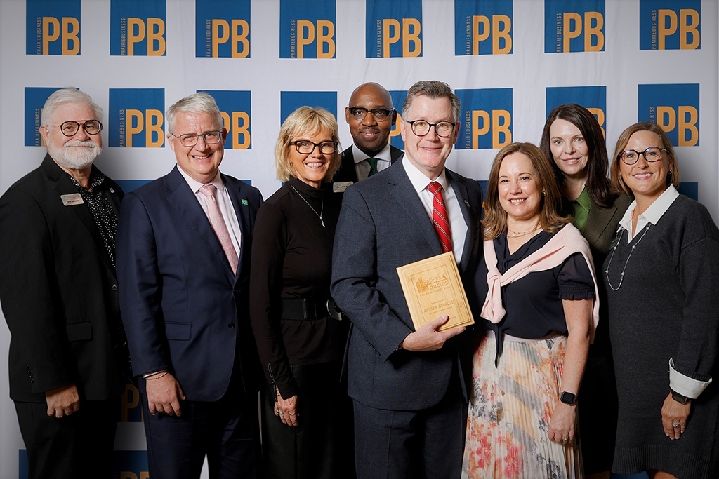 UND President Andrew Armacost, center, holds his 2026 Leaders & Legacies award while posing with fellow attendees at the Prairie Business awards reception.