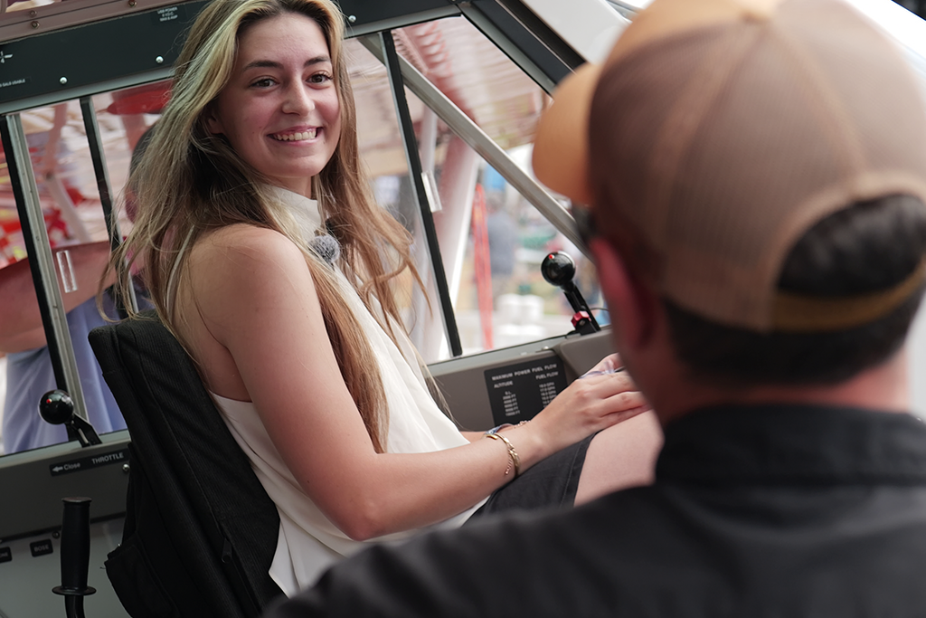 Ashley Almquist smiles while sitting in the pilot’s seat of an Aviat Husky airplane.
