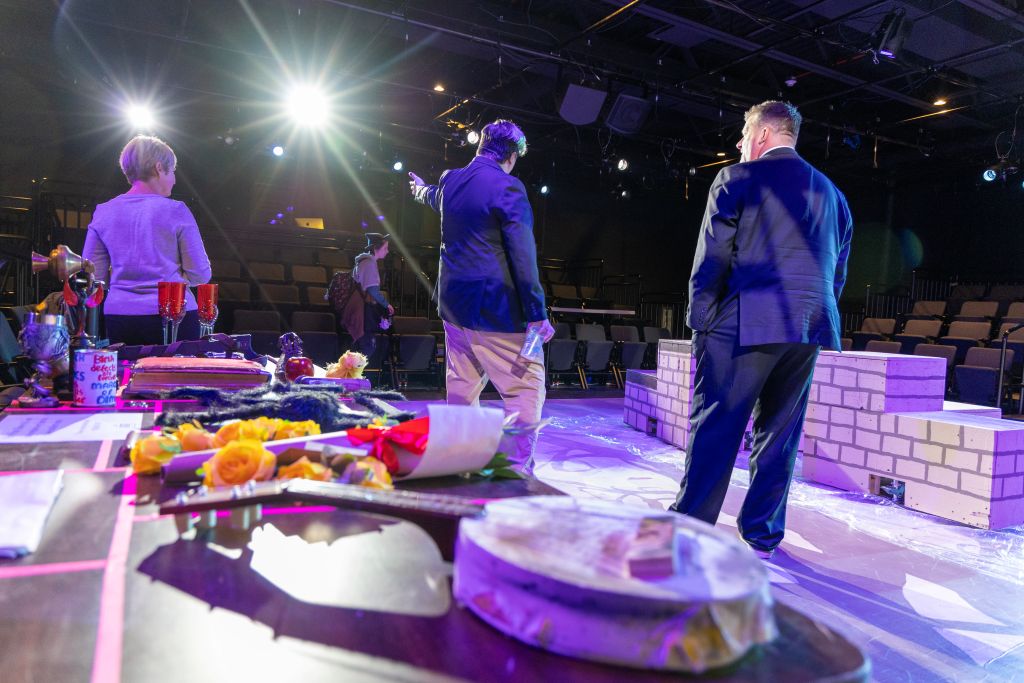 Visitors stand on Starcher Stage among set pieces and props for “The Addams Family”